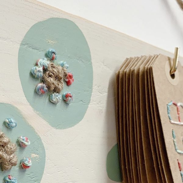 colgador de madera natural bordado con calendario de papel